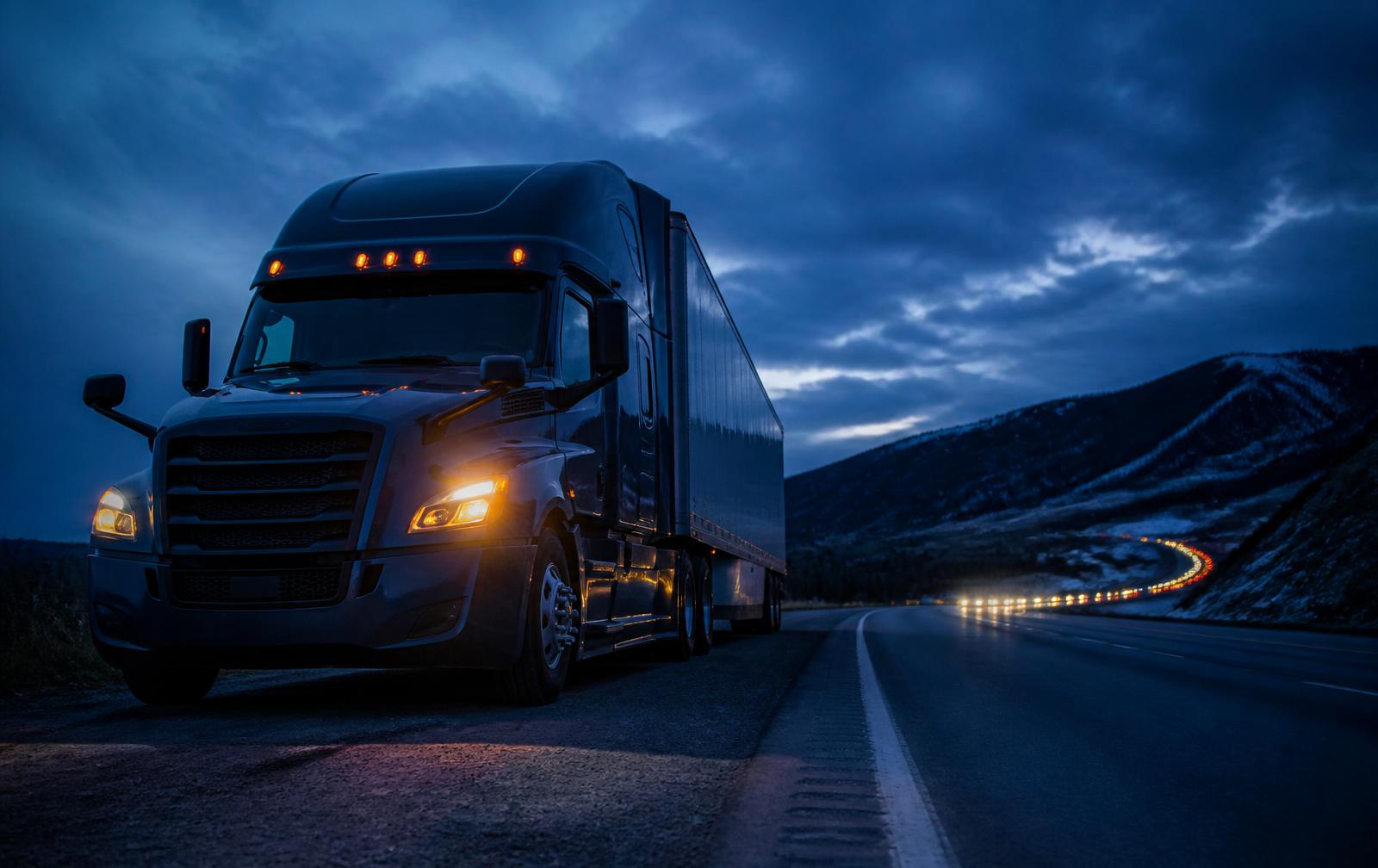 Heavy-duty commercial truck stopped on a highway shoulder at dusk
